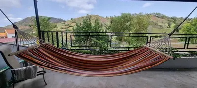 a hammock on a balcony with a view of mountains at Recanto da Montanha in Rui Vaz