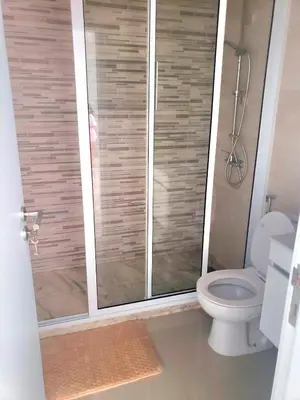 a bathroom with a toilet and a glass shower at Apartamentos Beira-Mar in Mindelo