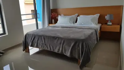 a bedroom with a large bed with white pillows at Apartamentos Beira-Mar in Mindelo