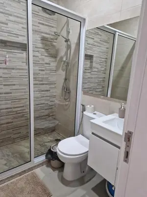 a bathroom with a toilet and a shower and a sink at Apartamentos Beira-Mar in Mindelo