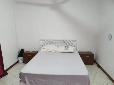 a bedroom with a white bed with two night stands at Seaview Apartment in Tarrafal