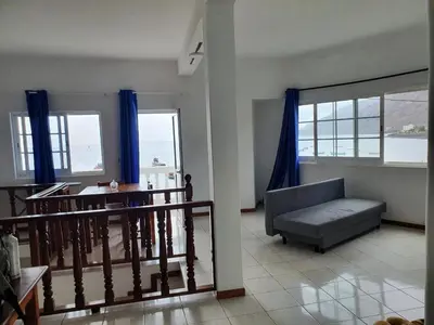 a living room with a couch and a table and windows at Seaview Apartment in Tarrafal