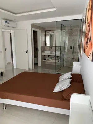 a bedroom with a large bed and a shower at Apartamento Deluxe Santa Filomena in Mindelo