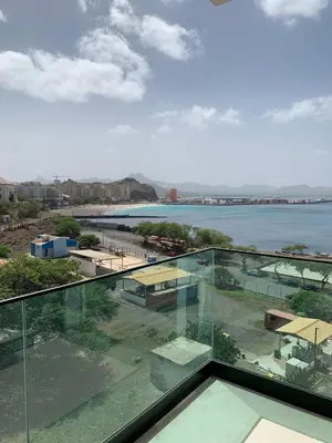 a glass balcony with a view of the water at Apartamento Deluxe Santa Filomena in Mindelo