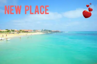 a beach with a group of people in the water at Porto Antigo 2 Beach Club in Santa Maria