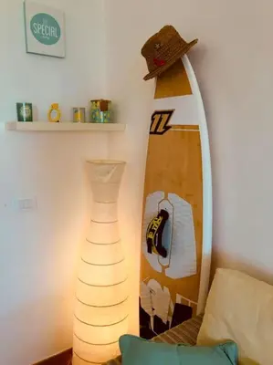 a vase sitting next to a surfboard in a room at Porto Antigo 2 Beach Club in Santa Maria