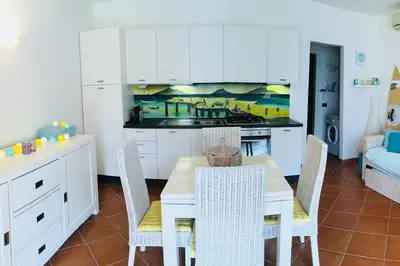 a kitchen and dining room with a table and chairs at Porto Antigo 2 Beach Club in Santa Maria