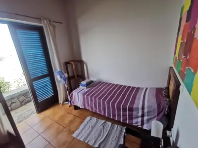 a bedroom with a bed and a sliding door at Casa Praia Tarrafal de Monte Trigo in Seladinha