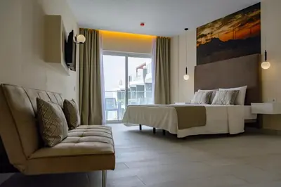 a bedroom with a large bed and a couch at Ouril Mindelo in Mindelo