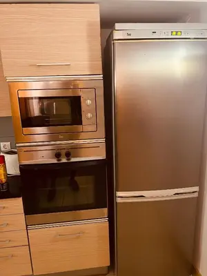 a microwave and a refrigerator in a kitchen at Apartamento T2 equipado Vila Verde in Santa Maria