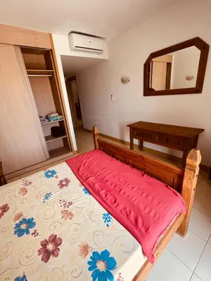 a bedroom with a bed with a red blanket on it at Apartamento T2 equipado Vila Verde in Santa Maria