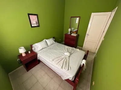 a bedroom with a bed in a green wall at Djon’s place in Baia das Gatas