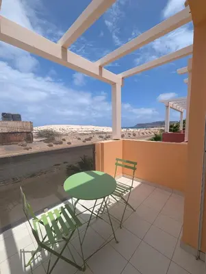 a patio with two chairs and a table on a balcony at Large Townhouse close to Beach in Sal Rei