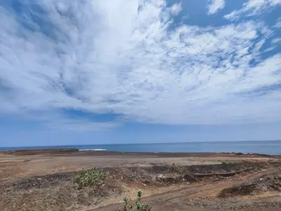 a beach with a cloudy sky and the ocean at Casa Andrade Delgado - Rocha Grande in Ponta do Sol