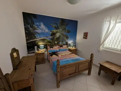 a bedroom with a bed with a painting on the wall at Vista Oceano - Boa Vista Island in Sal Rei