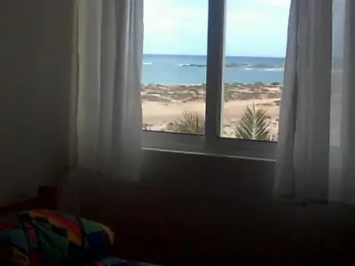a bedroom with a window with a view of the beach at Vista Oceano - Boa Vista Island in Sal Rei