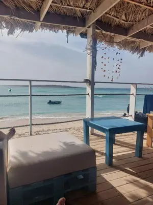 a room with a bed and a table and the beach at Vista Oceano - Boa Vista Island in Sal Rei