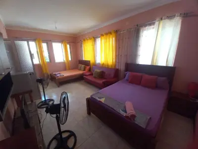 a bedroom with a bed and a couch in a room at Casa Barreto in Tarrafal