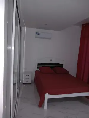 a bedroom with a red bed and a red curtain at Edifício 2PALMA in Praia