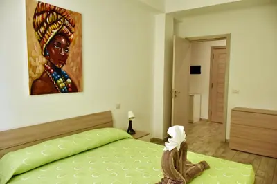 a bedroom with a bed with a painting on the wall at BoaOp Apartments in Sal Rei