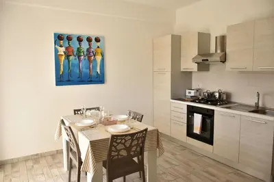 a kitchen with a table with chairs and a painting on the wall at BoaOp Apartments in Sal Rei