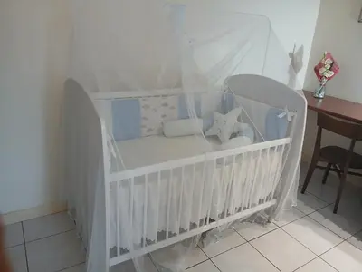 a white crib with a white canopy in a room at Lalas ASA in Praia