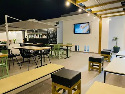 a restaurant with tables and chairs and a tv on the wall at Chez Maria Julia Boutique Hotel in Praia