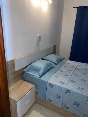 a small bedroom with a bed with blue pillows at Katila-Rooms in Santa Maria