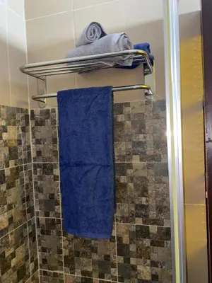 a bathroom with blue towels on a towel rack at Katila-Rooms in Santa Maria