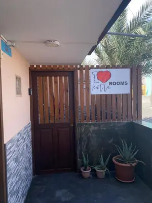 a door to a room with potted plants and a sign at Katila-Rooms in Santa Maria