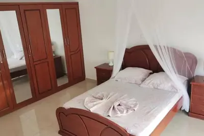 a bedroom with a bed with a mosquito net at Maison familiale à Tarrafal. in Tarrafal