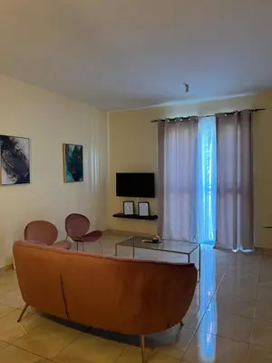 a living room with a couch and a tv at Good Dreams Apartment in Praia