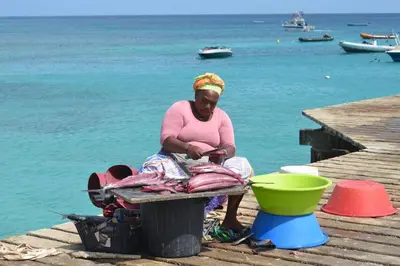 a woman sitting on a dock with a fish at Sol & Lar No stress in Santa Maria