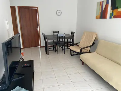 a living room with a couch and a table and chairs at Apartamento Santos in Ribeira Grande