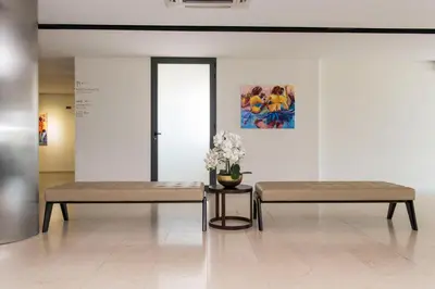 two benches in a room with a vase of flowers at Hotel Pérola in Praia