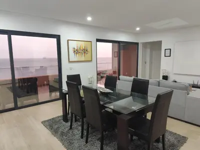 a dining room with a table and chairs and a couch at Ocean Mirror Apartment in Praia