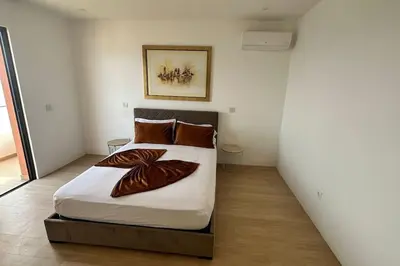 a bedroom with a large bed with brown pillows at Ocean Mirror Apartment in Praia
