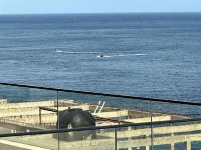 a view of the ocean with people in the water at Ocean Mirror Apartment in Praia