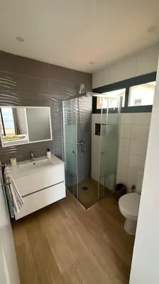 a bathroom with a shower and a sink and a toilet at Ocean Mirror Apartment in Praia