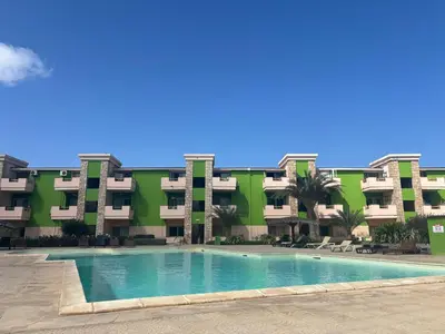 an apartment building with a swimming pool in front of it at Cozy Apartment with Pool, near Beach and Center in Santa Maria
