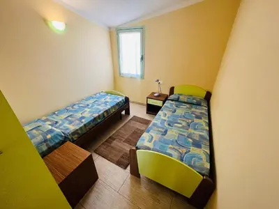 a small room with two beds and a window at Cozy Apartment with Pool, near Beach and Center in Santa Maria