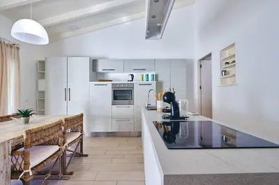 a kitchen with white cabinets and a counter top at Beach Villa - By Bobbywashere in Santa Maria