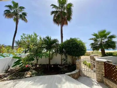 a house with palm trees and a fence at Beach Villa - By Bobbywashere in Santa Maria