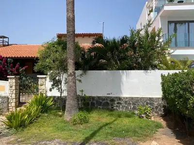 a white fence with a palm tree in front of a house at Beach Villa - By Bobbywashere in Santa Maria