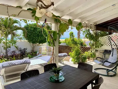 a patio with a table and chairs and plants at Beach Villa - By Bobbywashere in Santa Maria