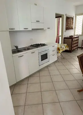 a kitchen with white cabinets and a tile floor at KatlantiK Estoril Deluxe in Sal Rei