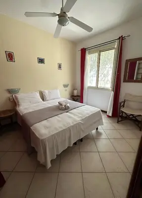 a bedroom with a large bed with a ceiling fan at KatlantiK Estoril Deluxe in Sal Rei