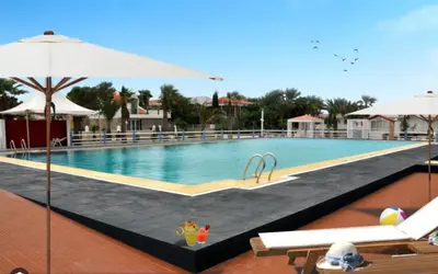 a large swimming pool with chairs and an umbrella at Vila Paradise Sea & Swimming Pool View in Beirona