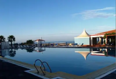a pool of water with a building in the background at Vila na Mágica Baía da Murdeira in Beirona