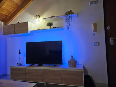 a flat screen tv sitting on a entertainment center with a blue light at Soleil Beach House in Santa Maria